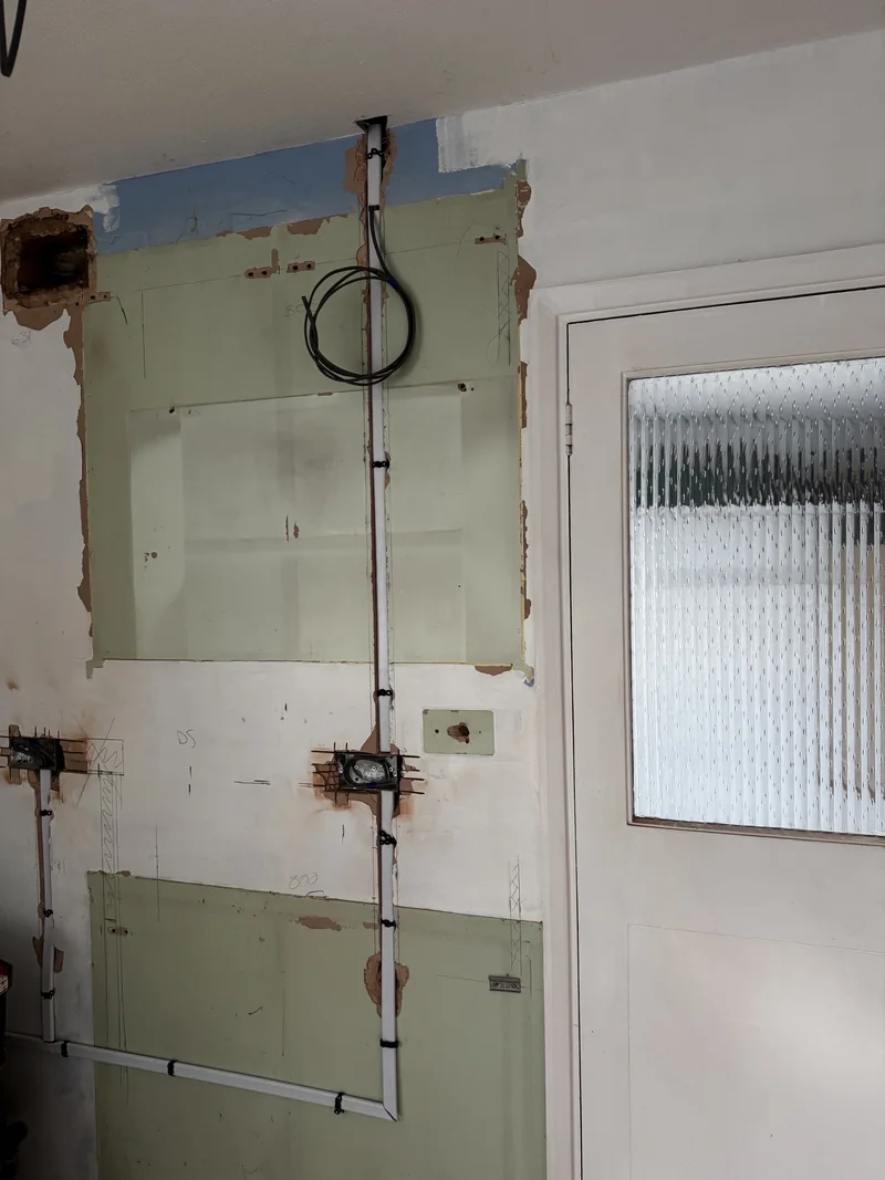 Kitchen rewire first fix in Northampton with chased solid wall cable routes beside the back door
