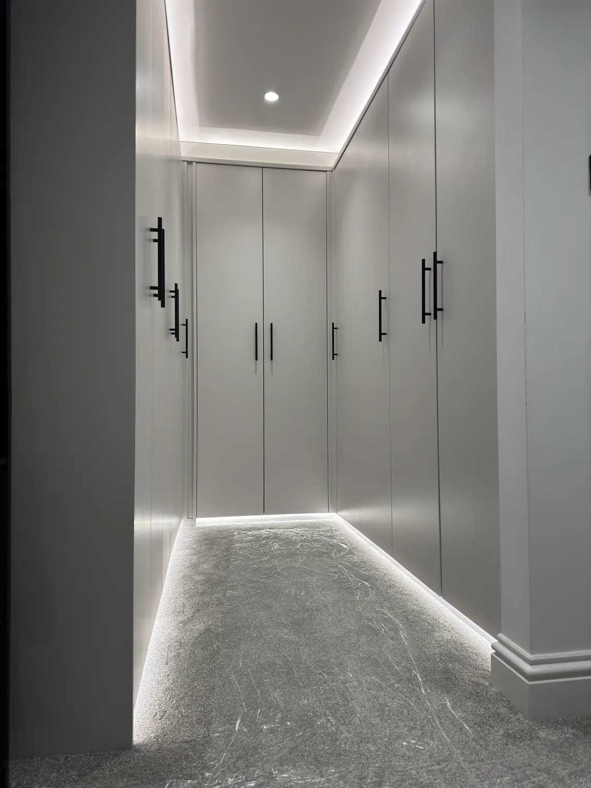 Luxury walk-in wardrobe with concealed LED strip lighting and recessed spotlights in Kettering