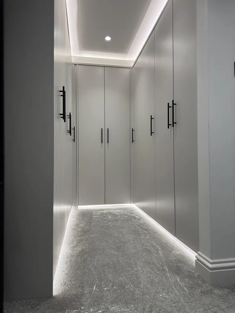 Luxury walk-in wardrobe lighting installation with upper and lower LED strip lighting in Kettering