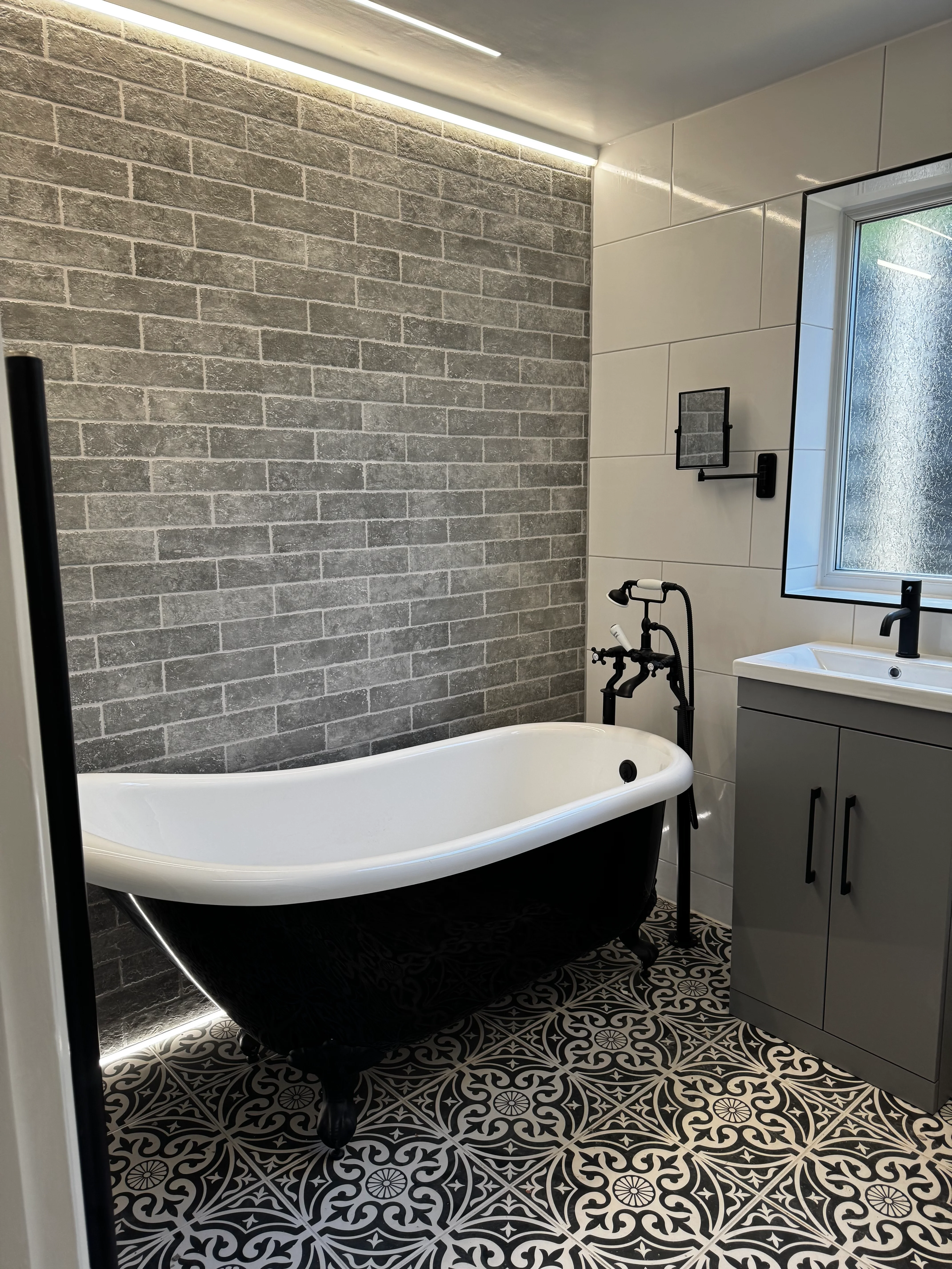 Luxury bathroom renovation — marble tiles, LED illuminated mirror, black shower screen