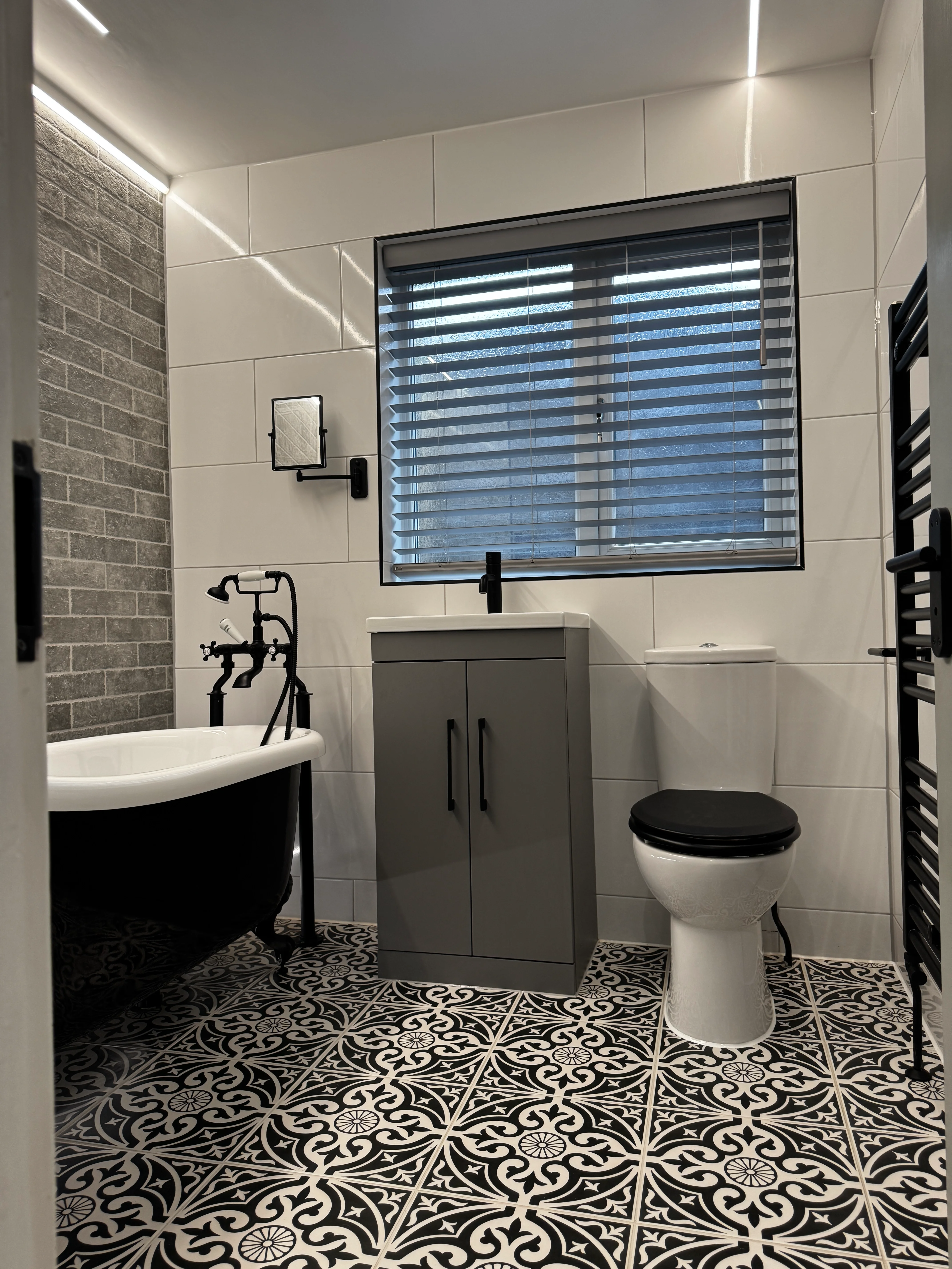 Bathroom renovation with marble tiles and black heated towel rail