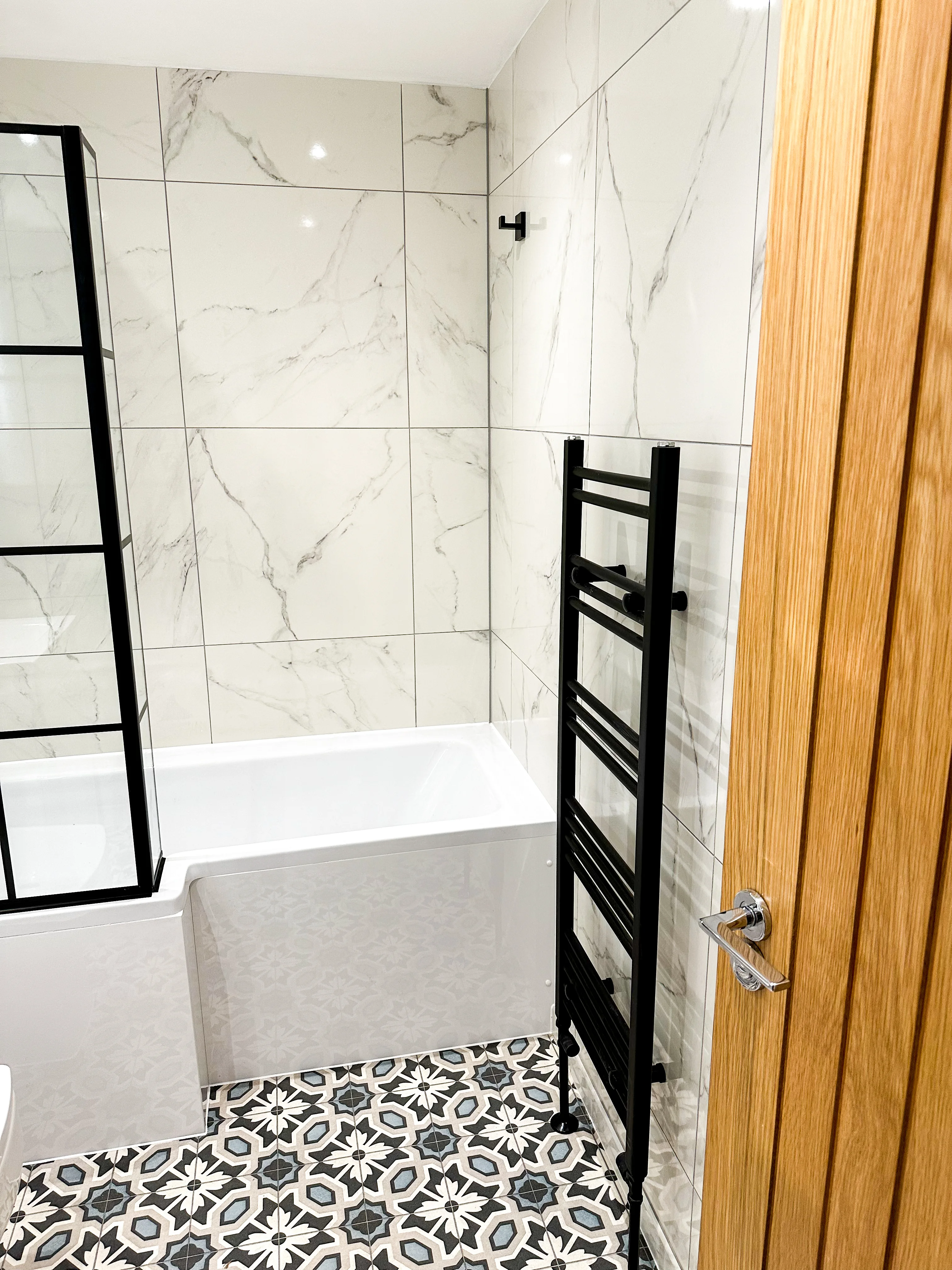 Walk-in shower with large-format tiles in a luxury bathroom renovation by Entigen