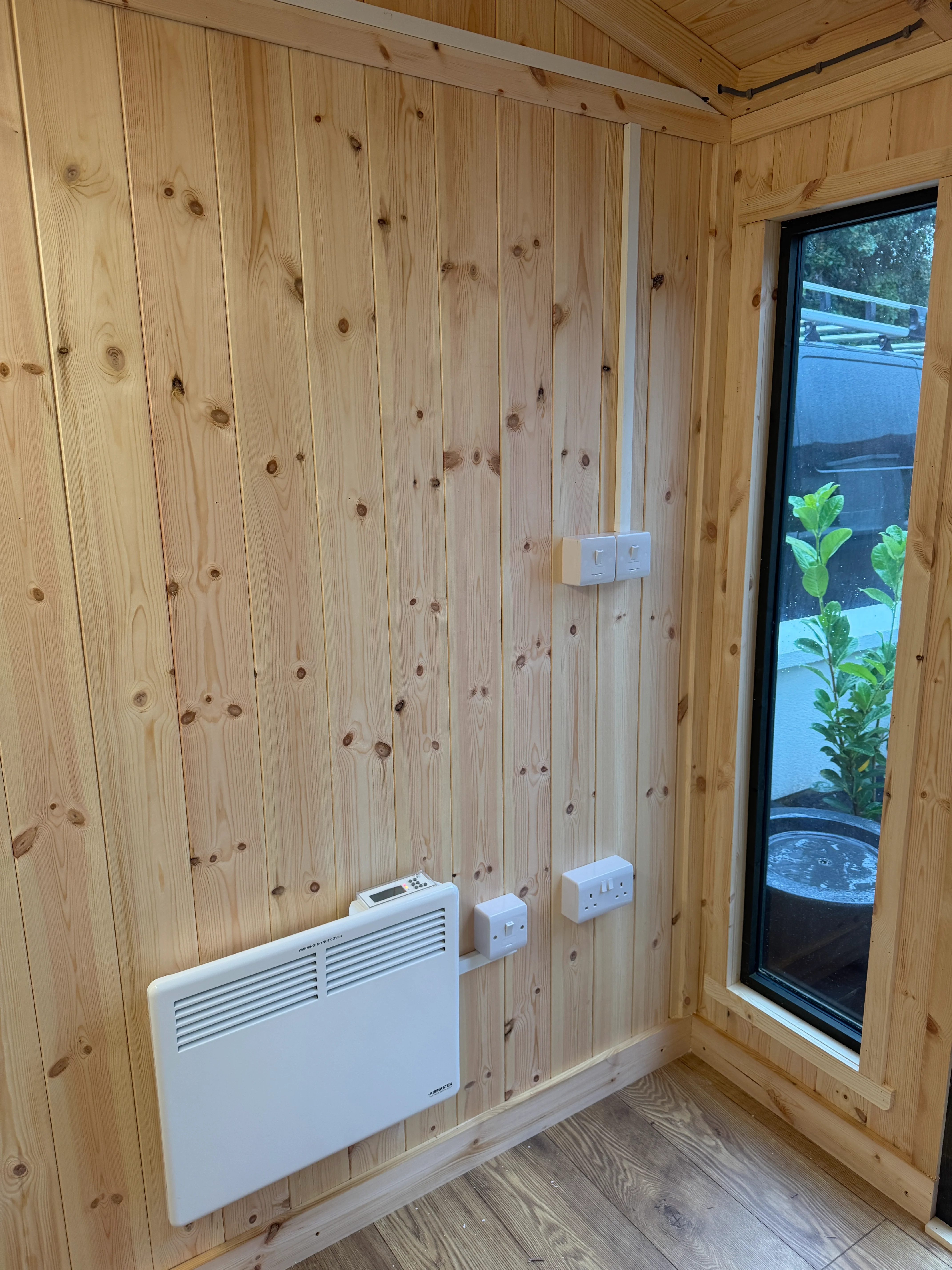 Garden-room interior with electrical sockets and an electric heater